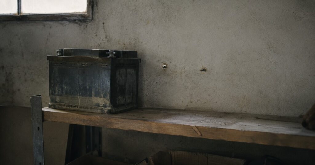 Batería física en una estantería de garaje junto al hueco vacío donde había otra